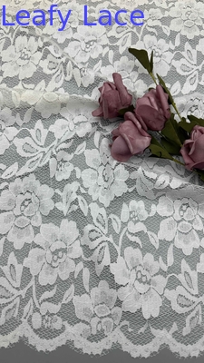 Tissu de dentelle en blanc, décoré de motifs floraux délicats et de bords en écharpe luxueusement
